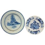 TWO GRADUATED DUTCH DELFTWARE PLATES PAINTED WITH AN ISLAND OR BAMBOO AND PEONY PATTERN, 23 AND 30CM