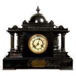 A FRENCH BELGE NOIR TEMPLE FORM MANTLE CLOCK WITH ENGRAVED BRASS TABLET 'PRESENTED TO ERNEST A