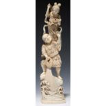 A JAPANESE IVORY OKIMONO OF A FISHERMAN DRAWING IN HIS NET, A MYTHOLOGICAL FEMALE FIGURE ON HIS