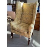 A GEORGE III STYLE MAHOGANY WINGBACK ARMCHAIR ON SQUARE TAPERING FORE LEGS AND BRASS CASTORS