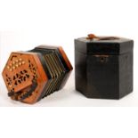 A FRETTED MAHOGANY STAINED WOOD CONCERTINA, 10 + 11 BUTTONS IN BLACK FITTED WOOD BOX