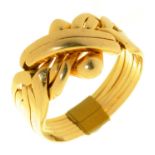 A GOLD PUZZLE RING, MARKED 18K, 10.5G, SIZE U ½ LIGHT SURFACE WEAR CONSISTENT WITH AGE AND USE