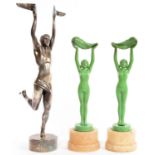 A PAIR OF ART DECO GREEN PAINTED SPELTER STATUETTES OF A NUBILE YOUNG WOMAN HOLDING ALOFT A LEAF,