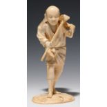 A JAPANESE SECTIONAL IVORY FIGURE OF A FARMER CARRYING A BASKET OVER HIS SHOULDER AND HOLDING A