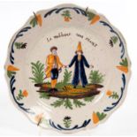 A  BRITTANY FAIENCE PLATE PAINTED WITH A COUPLE AND INSCRIBED LE MALHEUR NOUS PEUNIT, 23CM DIAM,