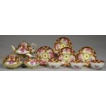 A JAPANESE NORITAKE STYLE TEA SERVICE, PAINTED WITH CABBAGE ROSES RESERVED ON A PRIMROSE AND