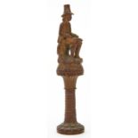 A CARVED WOOD SEATED MAN FIGURAL TOBACCO PIPE TAMPER,  OR SIMILAR, 11.5CM  H, 19TH C