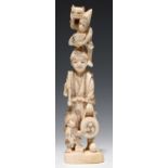 A JAPANESE IVORY OKIMONO OF A MONKEY TRAINER, 17.5CM H, MEIJI PERIOD