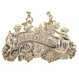 A GEORGE III SILVER 'BACCHANALIAN' WINE LABEL - MADEIRA, CHAINED, 6CM L, BY MATTHEW LINWOOD,