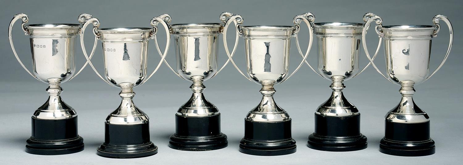 SIX MATCHING GEORGE V SILVER TWO HANDLED TROPHY CUPS, 11CM H EXCLUDING EBONISED BASE, BY MAPPIN