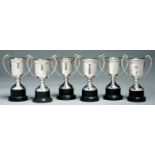 SIX MATCHING GEORGE V SILVER TWO HANDLED TROPHY CUPS, 11CM H EXCLUDING EBONISED BASE, BY MAPPIN