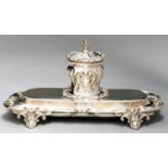 A VICTORIAN SILVER INKSTAND, THE LOBED CENTRAL WELL WITH DOMED LID AND WRYTHEN FLUTED FINIAL, ON