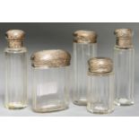 A SET OF FIVE EDWARD VII SILVER CAPPED FACETED GLASS JARS AND BOTTLES FROM A DRESSING CASE, 13.5CM H