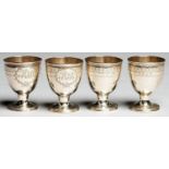A SET OF FOUR GEORGE III SILVER EGG CUPS, ENGRAVED WITH A BAND OF SCALE WORK AND CONTEMPORARY