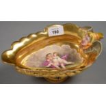 A GERMAN PORCELAIN GILT GROUND SAUCE BOAT, WINGED GROTESQUE MASK HANDLE TERMINALS, PAINTED TO THE