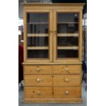 A VICTORIAN WAXED PINE LINEN PRESS, THE UPPER PART FITTED WITH TWO TRAYS AND ONE SHELF ENCLOSED BY