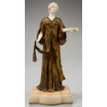 LOUIS OUVET. AN ART NOUVEAU GILT BRONZE AND IVORY STATUETTE OF A GIRL GATHERING ROSES, ON BOW