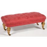 A SALON STOOL UPHOLSTERED IN BUTTONED RED BROCADE ON VICTORIAN TURNED GILTWOOD FEET AND BRASS