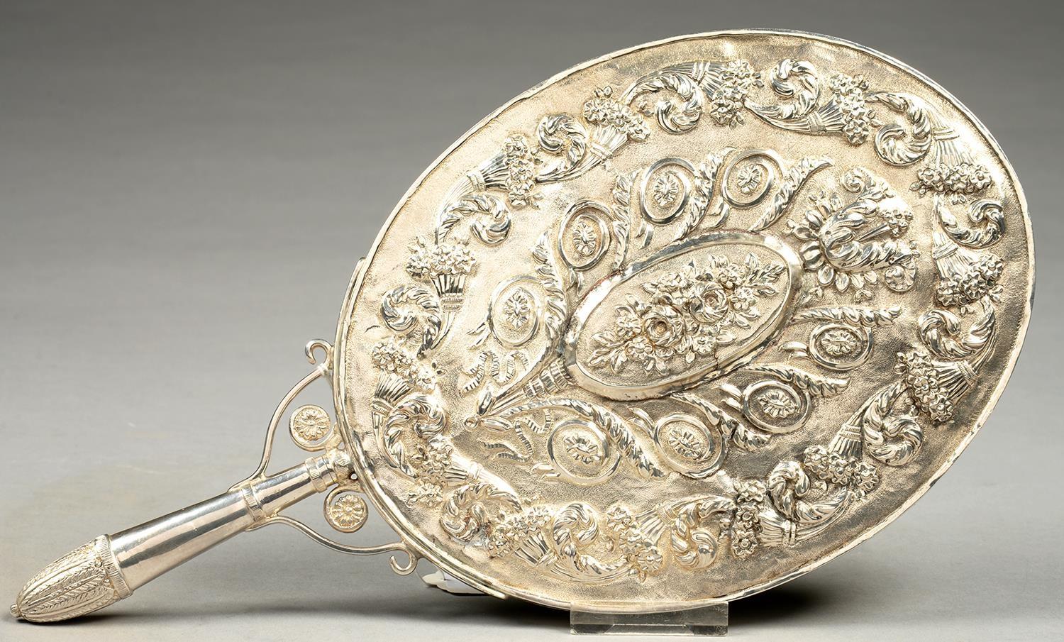 AN OTTOMAN SILVER HAND MIRROR, CHASED IN HIGH RELIEF WITH ROSES AND OTHER FLOWERS FRAMED BY