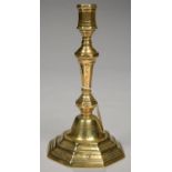 A NORTHERN EUROPEAN BRASS CANDLESTICK, THE PRICKED DECORATION INCLUDING DIAMONDS AND ROSETTES, ON