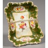 AN ENGLISH PORCELAIN GREEN GROUND BASKET, PAINTED WITH PANELS OF FLOWERS IN RAISED GILT RESERVES,