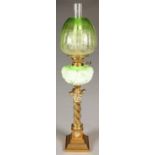 AN EDWARDIAN BRASS COLUMNAR OIL LAMP WITH MOULDED GREEN GLASS FOUNT AND BRASS DUPLEX BURNER, THE