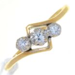 A THREE STONE DIAMOND CROSSOVER RING, THE GOLD HOOP MARKED 18CT PLAT, 2.9G, SIZE P Good condition