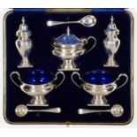 A GEORGE V FIVE PIECE SILVER CONDIMENT SET, VASE SHAPED, BLUE GLASS LINERS, PEPPERETTE 7.5CM H, BY