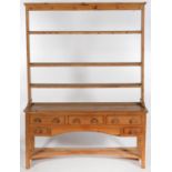 A WAXED PINE DRESSER AND A PINE PLATE RACK, THE DRESSER FITTED WITH DRAWERS AND TURNED KNOBS ON