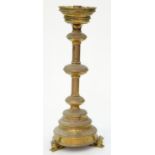 A GOTHIC STYLE BRASS FLOOR STANDING CANDLESTICK IN 16TH C STYLE, ON THREE RECUMBENT LION FEET, 133CM