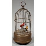 A CLOCKWORK SINGING BIRDS-IN-A-CAGE AUTOMATON, THE BRASS AND WIRE BIRDCAGE WITH EMBOSSED BASE ON