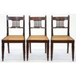 A SET OF THREE VICTORIAN GRAINED ROSEWOOD AND CANED DINING CHAIRS ON REEDED TAPERING TURNED