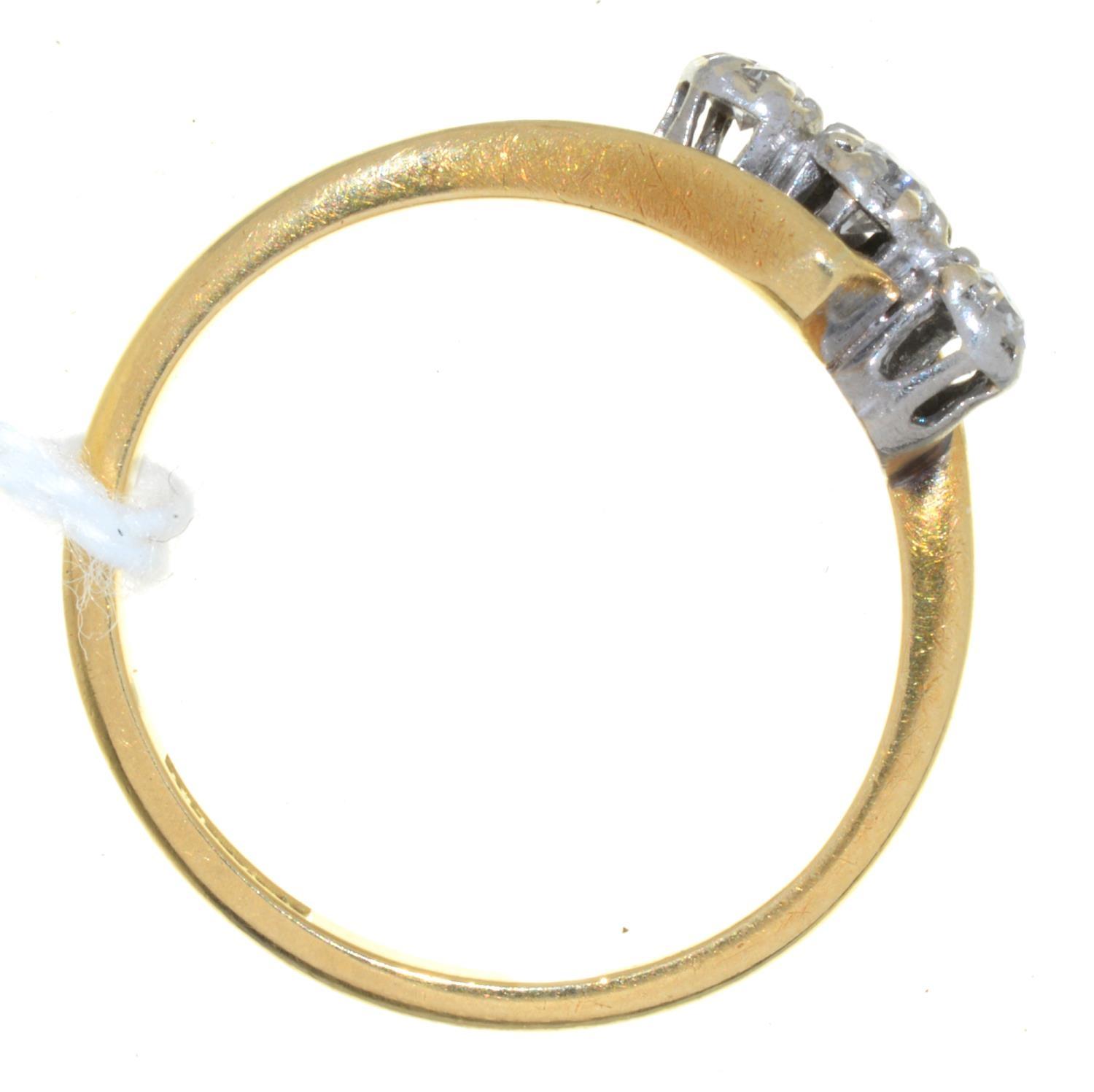 A THREE STONE DIAMOND CROSSOVER RING, THE GOLD HOOP MARKED 18CT PLAT, 2.9G, SIZE P Good condition - Image 2 of 2