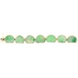A GOLD AND CHINESE CARVED JADEITE BRACELET OF SEVEN PEACH SHAPED LINKS, 175MM LONG, MARKED 14K
