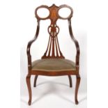 AN EDWARDIAN CARVED AND INLAID MAHOGANY SALON CHAIR WITH DOWN CURVED ARMS AND PADDED SEAT ON