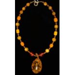 AN AMBER PENDANT SUSPENDED FROM A NECKLACE OF IMITATION AMBER AND OTHER BEADS, 60.55 Good condition