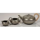 A LIBERTY & CO TUDRIC PEWTER TEA SERVICE, COMPRISING TEAPOT, SUGAR BOWL AND MILK JUG, TEAPOT WITH