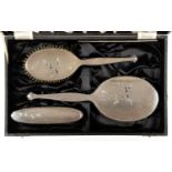 AN ELIZABETH II SILVER FOUR PIECE BRUSH SET, ENGRAVED WITH BLOSSOM AND ENGINE TURNED, BY ADIE