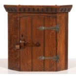 A MINIATURE SPLAY FRONTED OAK HANGING CORNER CUPBOARD WITH NULLED CORNICE, LATCHED DOOR AND