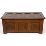 A CHARLES II OAK CHEST WITH FOUR PANEL LID, THE FRONT CARVED AT LATER DATE, THE INTERIOR WITH A