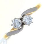 A DIAMOND CROSSOVER RING, THE ROUND BRILLIANT CUT DIAMONDS WEIGHING APPROXIMATELY 0.20CT, GOLD HOOP,