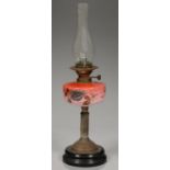 A VICTORIAN BRASS OIL LAMP WITH ENAMELLED PEACH BLOOM GLASS FOUNT, ON BLACK GLAZED POTTERY FOOT,
