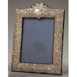 AN ELIZABETH II SILVER PHOTOGRAPH FRAME, THE MOUNT DIE STAMPED WITH TRAILING FOLIAGE, BACKED ON BLUE