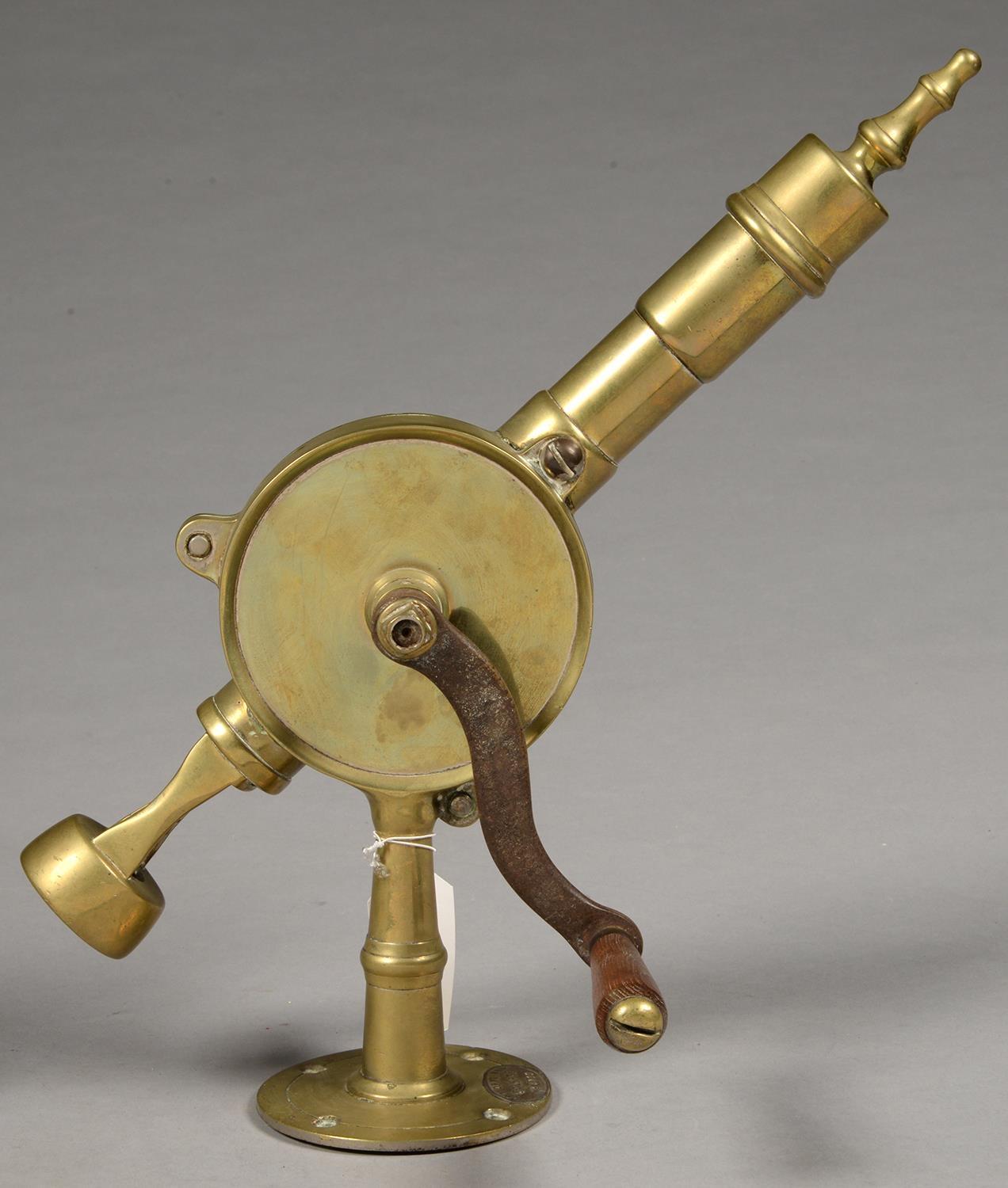 A LATE VICTORIAN OR EDWARDIAN BRASS BARMAN'S CORKSCREW WITH IRON AND BEECH HANDLE, THE CIRCULAR BASE