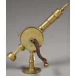 A LATE VICTORIAN OR EDWARDIAN BRASS BARMAN'S CORKSCREW WITH IRON AND BEECH HANDLE, THE CIRCULAR BASE