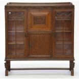 AN OAK SIDE-BY-SIDE CABINET BUREAU, THE FRIEZE AND PANEL TO THE FLAP CARVED WITH GRAPEVINES, 124CM