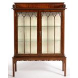 A MAHOGANY CHINA CABINET ENCLOSED BY TWO DOORS WITH TRIPLE ARCHED GLAZING BARS, ON SQUARE LEGS