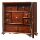 A MAHOGANY SPICE CUPBOARD  fitted with nine drawers with hinged brass loop handle enclosed by a