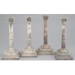 A SET OF FOUR GEORGE III SILVER  CANDLESTICKS   the slightly tapered, stop fluted column beneath