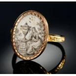 A GOLD MOURNING RING, 1779 set with an oval miniature painted en grisaille with a lady seated beside